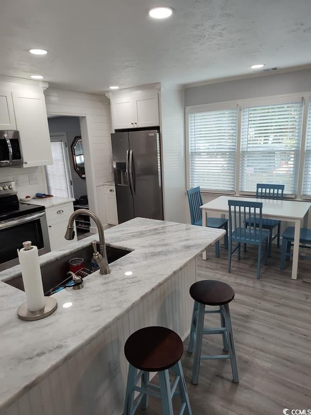 725 Juniper Dr, Surfside Beach, SC 29575 - kitchen featuring stainless steel appliances, a breakfast bar, healthy amount of natural light, and recessed lighting
