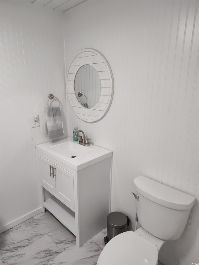 725 Juniper Dr, Surfside Beach, SC 29575 - bathroom featuring marble look tiles, vanity, toilet, and wood walls