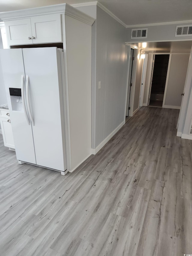 725 Juniper Dr, Surfside Beach, SC 29575 - kitchen with white fridge with ice dispenser, ornamental molding, light wood-style floors, white cabinets, and baseboards
