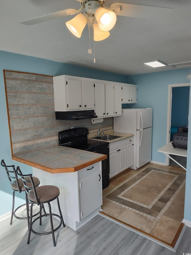 725 Juniper Dr, Surfside Beach, SC 29575 - kitchen with freestanding refrigerator, black / electric stove, white cabinetry, and a textured ceiling
