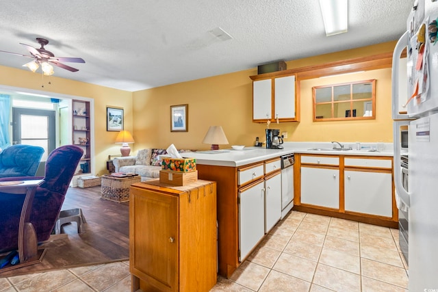 kitchen with a peninsula, open floor plan, light countertops, a textured ceiling, and a ceiling fan