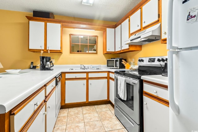 kitchen featuring appliances with stainless steel finishes, under cabinet range hood, a sink, light countertops, and white cabinetry