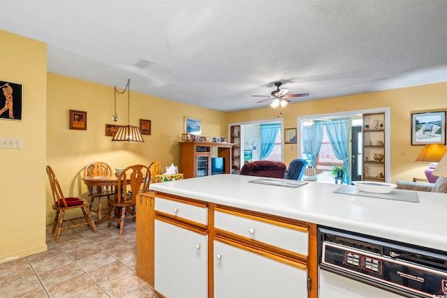 kitchen with open floor plan, ceiling fan, light countertops, a textured ceiling, and white cabinets