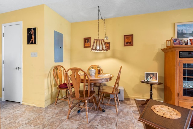 dining room featuring electric panel, baseboards, and a textured ceiling