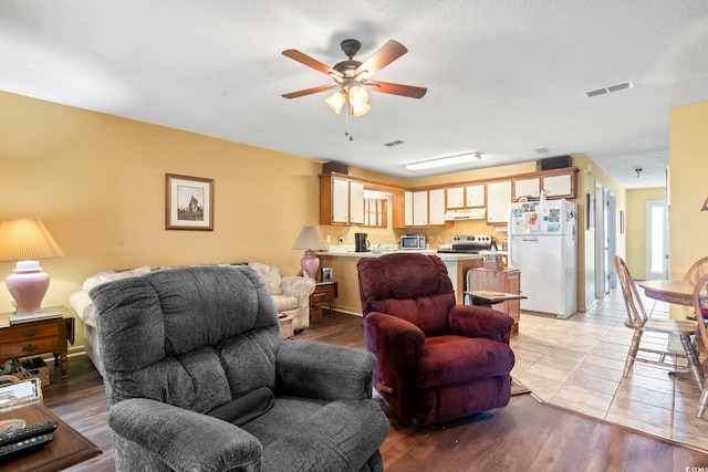 living room featuring ceiling fan and light wood-style flooring