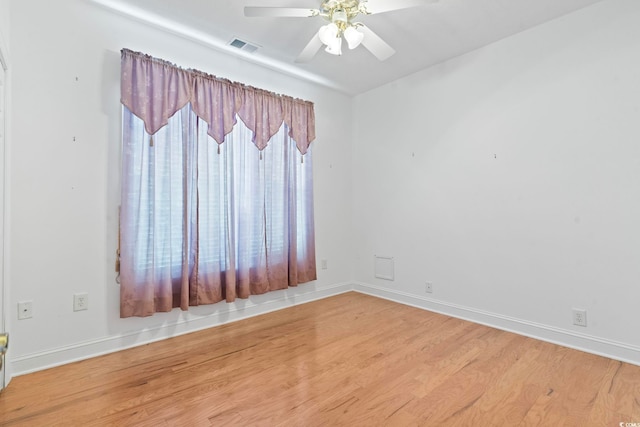 empty room featuring visible vents, baseboards, a ceiling fan, and wood finished floors