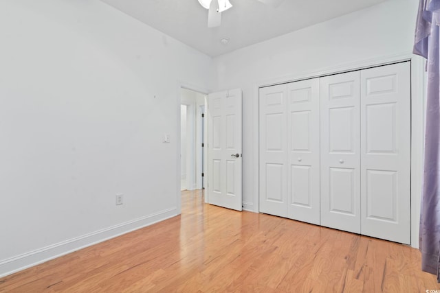 unfurnished bedroom featuring light wood-style floors, a closet, a ceiling fan, and baseboards