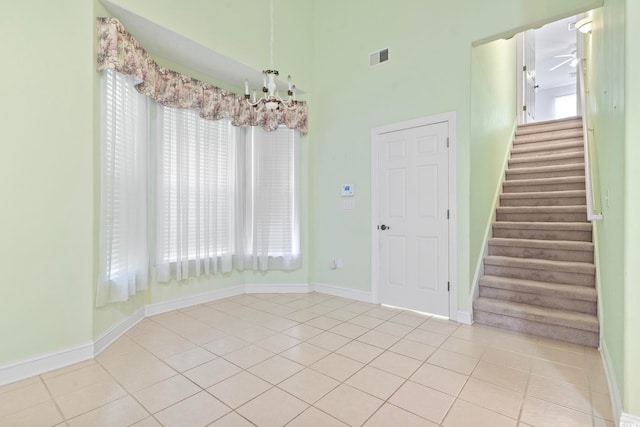interior space with stairway, baseboards, tile patterned flooring, and visible vents