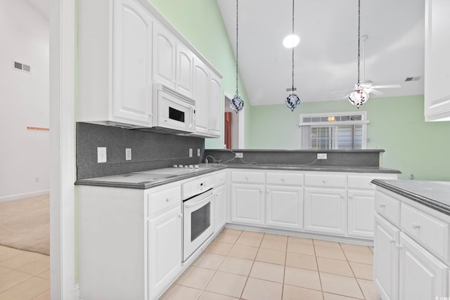 kitchen with dark countertops, visible vents, a ceiling fan, white appliances, and light tile patterned floors