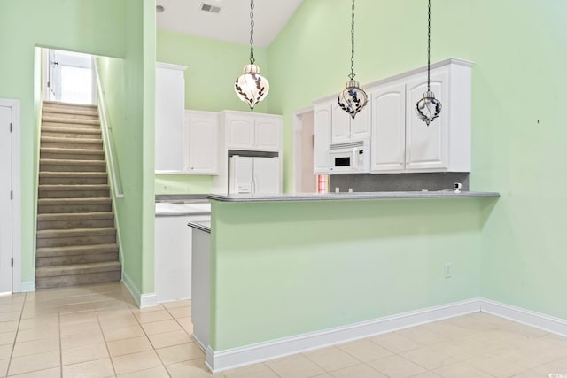 kitchen featuring high vaulted ceiling, white cabinetry, hanging light fixtures, and white appliances