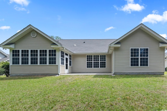 back of house with a patio area, roof with shingles, and a yard