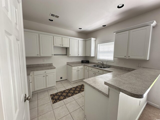 514 Hay Hill Ln Unit C, Myrtle Beach, SC 29579 - kitchen featuring a peninsula, a sink, a kitchen bar, white cabinets, and light tile patterned floors