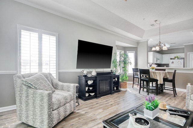 1533 Lanterns Rest Rd Unit 304, Myrtle Beach, SC 29579 - living room with ornamental molding, a notable chandelier, light wood-style floors, and a raised ceiling