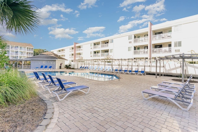 community pool with fence and a patio area