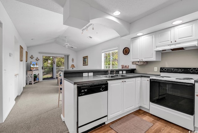 4430 Eastport Blvd Unit L15, Little River, SC 29566 - kitchen with white appliances, under cabinet range hood, a peninsula, dark countertops, and lofted ceiling