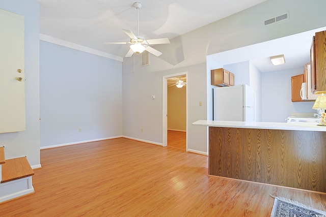 412 43rd Ave N, Myrtle Beach, SC 29577 - kitchen with white appliances, ceiling fan, brown cabinetry, and light wood finished floors