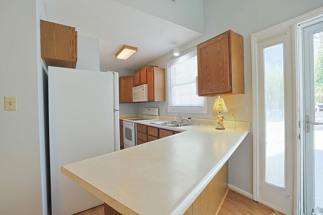 412 43rd Ave N, Myrtle Beach, SC 29577 - kitchen featuring white appliances, a sink, healthy amount of natural light, and brown cabinets