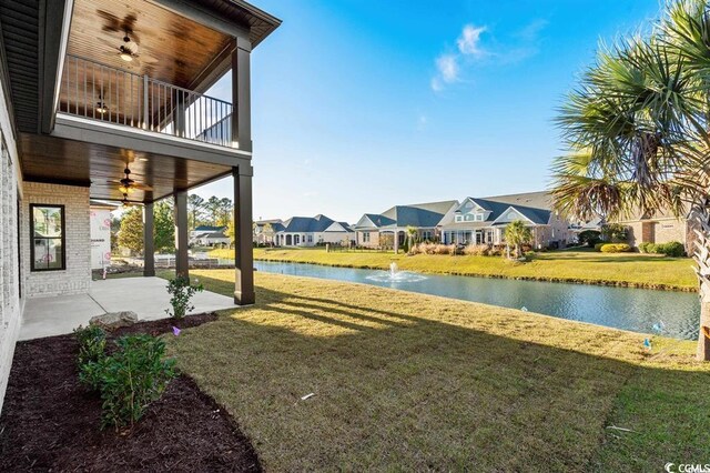 1219 Bentcreek Ln, Myrtle Beach, SC 29579 - view of grassy yard with a balcony, ceiling fan, a residential view, a water view, and a patio area