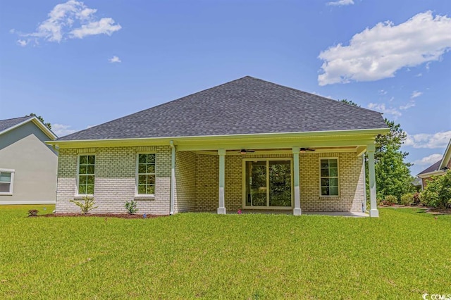 4932 S Island Dr, North Myrtle Beach, SC 29582 - back of property with brick siding, ceiling fan, roof with shingles, and a lawn