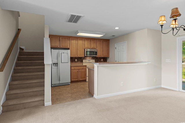 1004 Harvester Cir Unit 1004, Myrtle Beach, SC 29579 - kitchen with white appliances, light carpet, a chandelier, backsplash, and baseboards