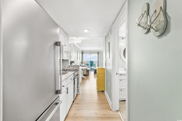 interior space featuring stacked washer / dryer and light wood-type flooring