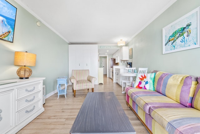 living area featuring baseboards, ornamental molding, and light wood finished floors