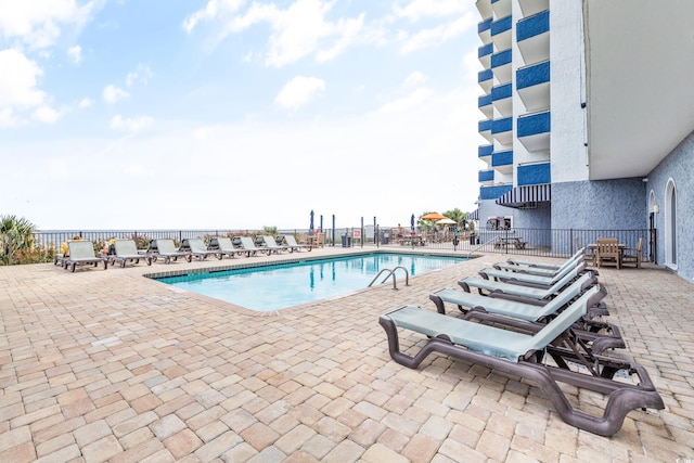 community pool featuring a patio and fence