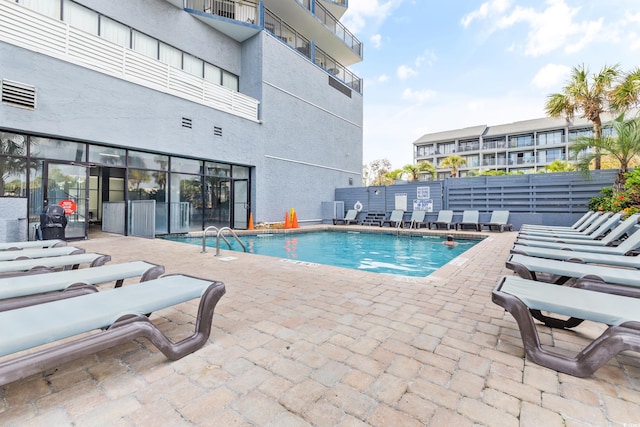 community pool featuring fence and a patio area