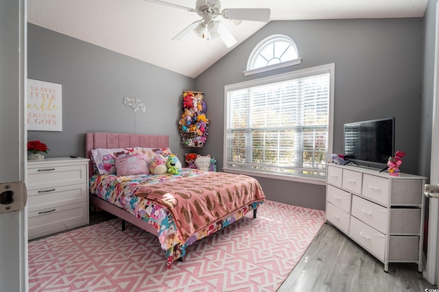 bedroom with light wood-type flooring, multiple windows, vaulted ceiling, and ceiling fan