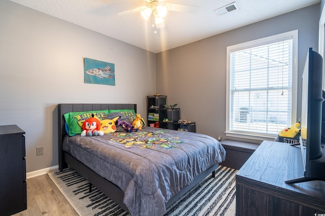 bedroom with wood finished floors, a ceiling fan, and baseboards