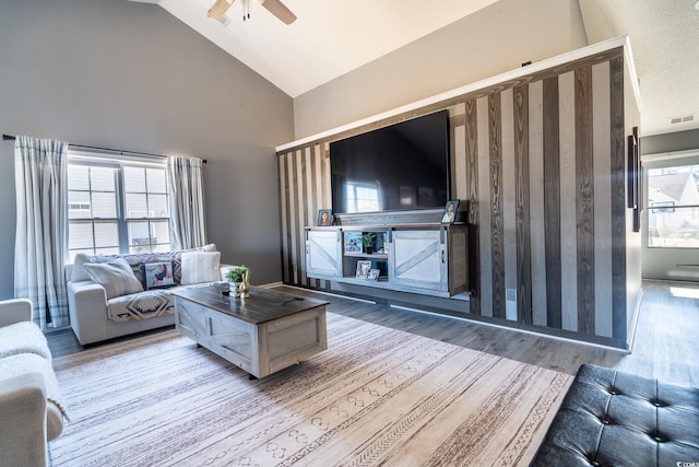 living room featuring wood finished floors, a ceiling fan, and high vaulted ceiling
