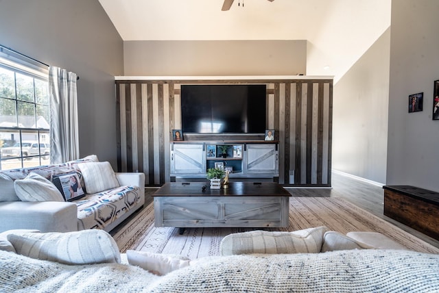 living room with wood finished floors, a ceiling fan, baseboards, and high vaulted ceiling