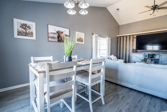 dining area featuring high vaulted ceiling, ceiling fan, wood finished floors, baseboards, and a chandelier