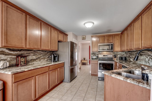 1001 Harvest View Ave, Conway, SC 29527 - kitchen with appliances with stainless steel finishes, tasteful backsplash, light tile patterned flooring, light stone countertops, and brown cabinetry