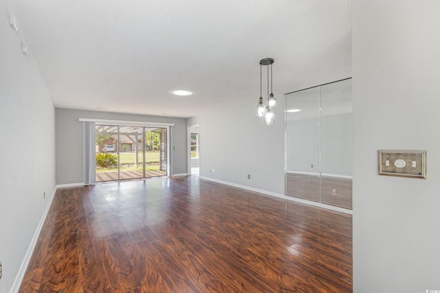 unfurnished room with baseboards and wood finished floors