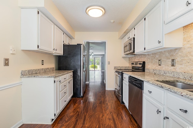 kitchen featuring dark wood-style flooring, white cabinets, and appliances with stainless steel finishes
