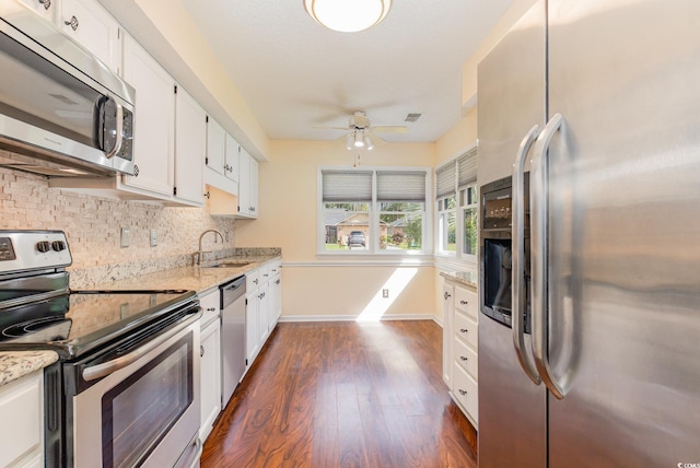 kitchen featuring tasteful backsplash, white cabinets, appliances with stainless steel finishes, and dark wood-type flooring