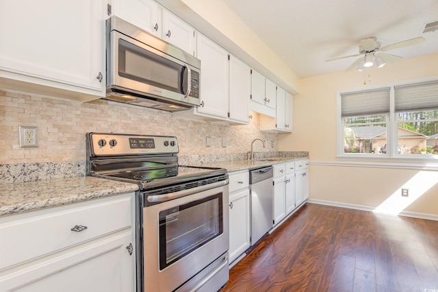 kitchen featuring a sink, dark wood-style flooring, stainless steel appliances, ceiling fan, and white cabinets