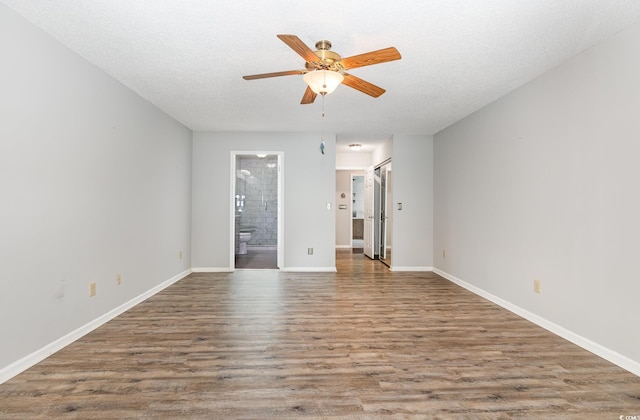 empty room featuring ceiling fan, wood finished floors, and baseboards