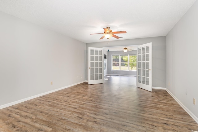 unfurnished room with ceiling fan, wood finished floors, french doors, and baseboards