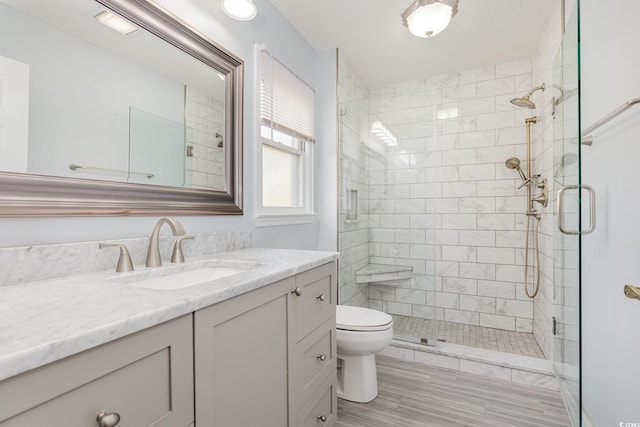 full bathroom with wood finished floors, a shower stall, toilet, and vanity