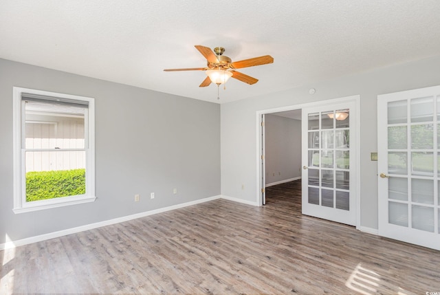 spare room with ceiling fan, plenty of natural light, and baseboards
