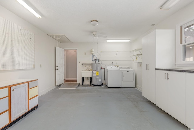 interior space with electric water heater, independent washer and dryer, attic access, baseboards, and a ceiling fan