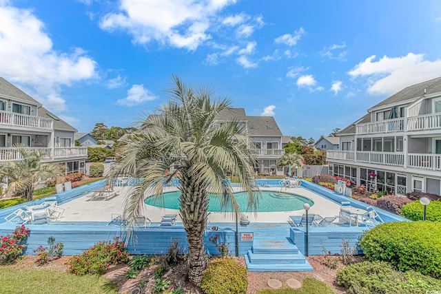 community pool with a residential view and a patio