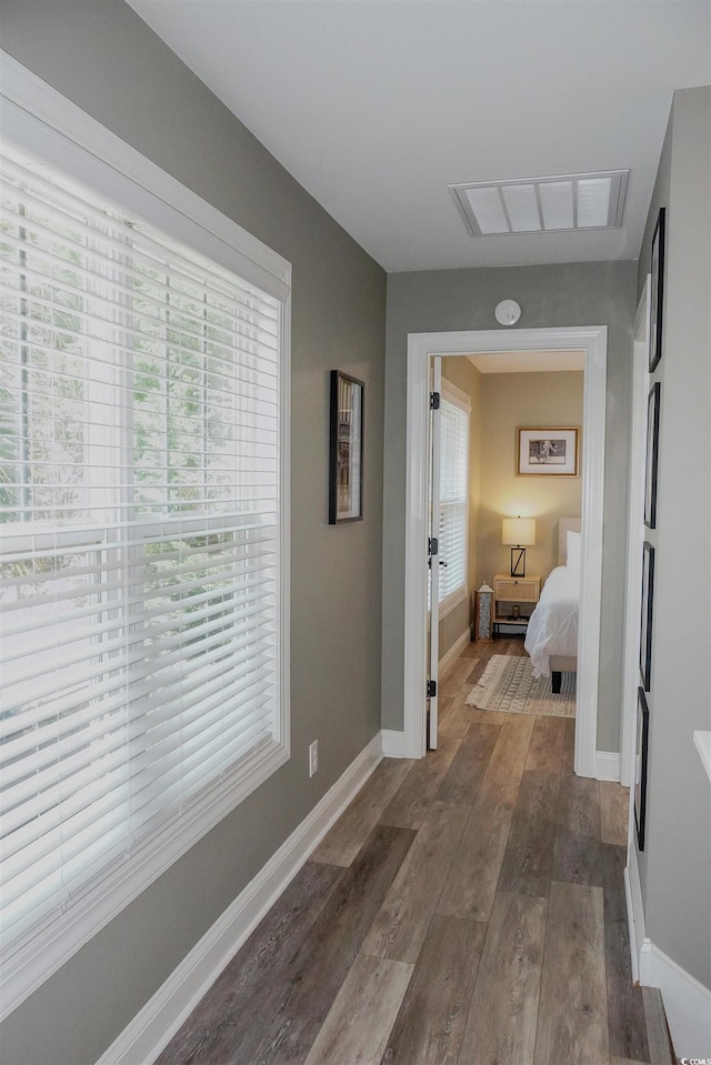 corridor featuring dark wood finished floors and baseboards