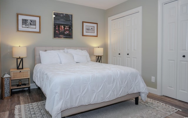 bedroom with wood finished floors, multiple closets, and baseboards