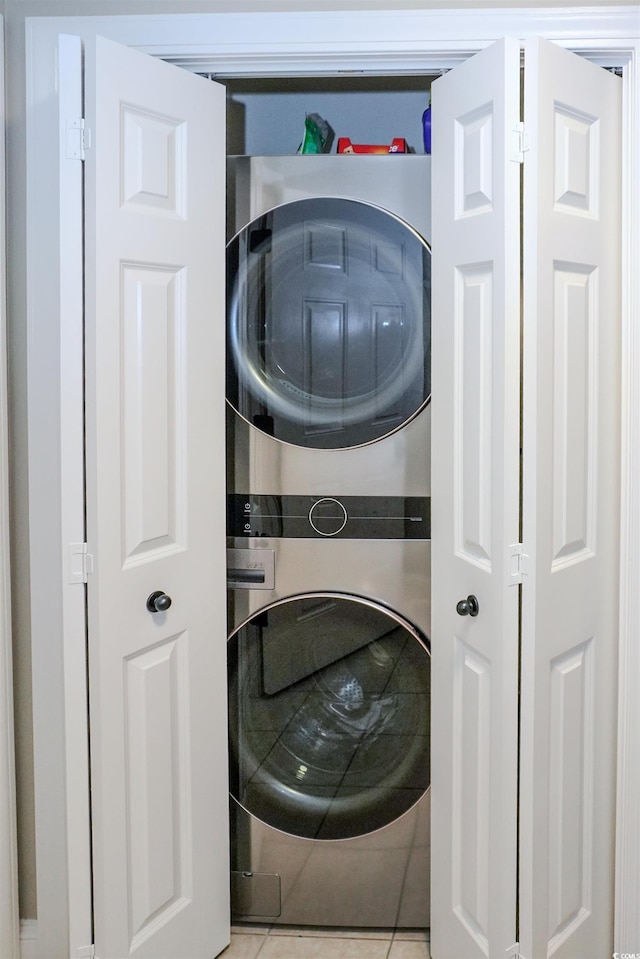 washroom with stacked washer and clothes dryer and tile patterned floors