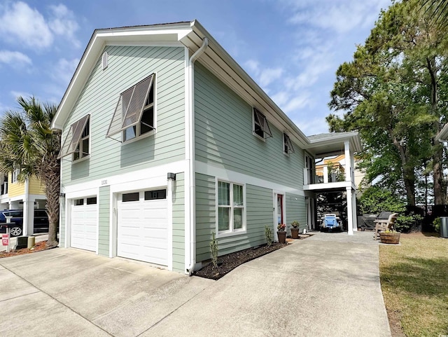 view of side of home with concrete driveway and a garage