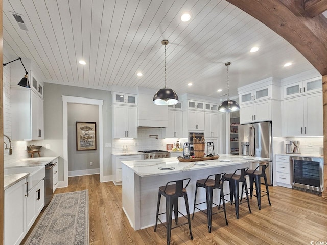 2300 Tansy Rd, Loris, SC 29569 - kitchen featuring beverage cooler, stainless steel appliances, backsplash, white cabinetry, and a kitchen breakfast bar