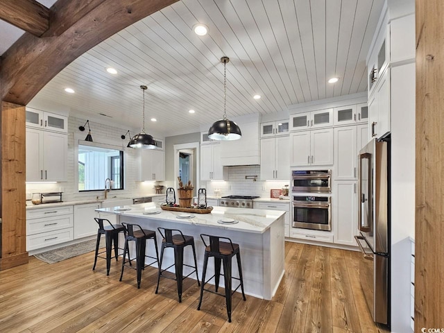 2300 Tansy Rd, Loris, SC 29569 - kitchen featuring appliances with stainless steel finishes, an island with sink, a breakfast bar area, light wood-style floors, and backsplash